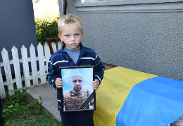 Син тримає фото загиблого батька: на Хотинщині попрощалися з Героєм-захисником Денисом Юликом
